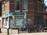 819675 Gezicht op de winkelpui van het hoekpand Rembrandtkade 21 (Drukkerij Van Nordenne) te Utrecht; op de voorgrond ...